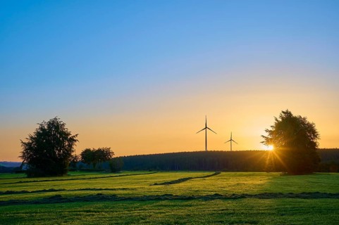 Wind turbines in a natural landscape at sunrise, with warm incidence of light, summer, Rohren,