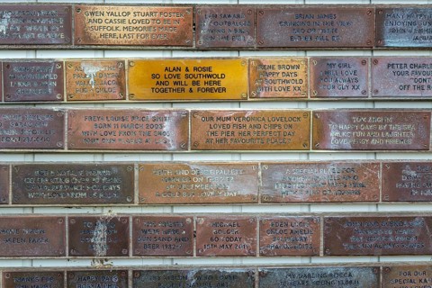 Sponsorship messages on copper plaques at Southwold Pier, Southwold, Suffolk, England, UK