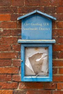 Girl Guides Guiding noticeboard derelict disused in ageing town short of children, Southwold,
