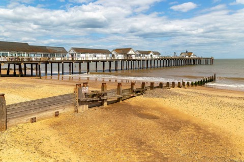 Wooden groyne running down sandy beach near pier, Southwold, Suffolk, England, UK
