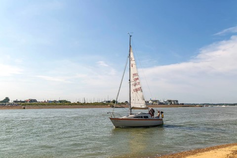 Sailing boat yacht at mouth of River Deben estuary, Bawdsey Quay, Suffolk, England, UK