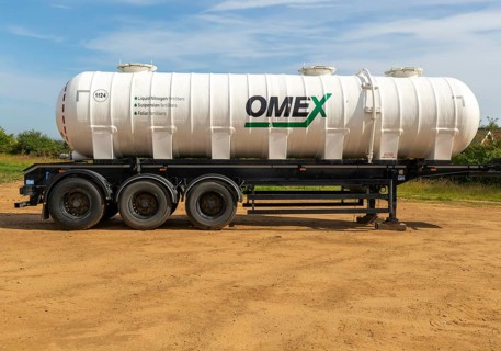 Omex fertiliser road tanker container waggon standing in field, Alderton, Suffolk, England, UK