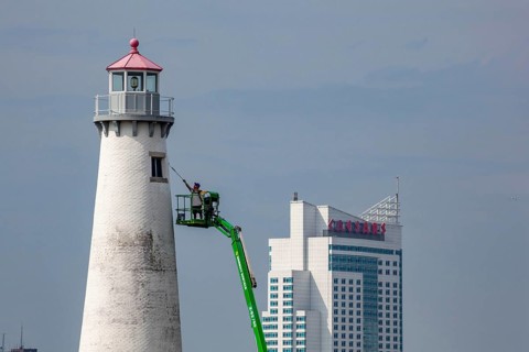 Detroit, Michigan - A worker on a lift paints the Milliken State Park Lighthouse. The lighthouse is