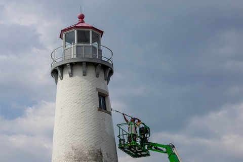 Detroit, Michigan - A worker on a lift paints the Milliken State Park Lighthouse. The lighthouse is
