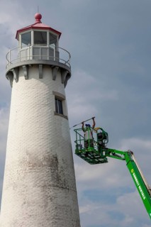 Detroit, Michigan - A worker on a lift paints the Milliken State Park Lighthouse. The lighthouse is