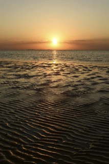 Sunset over the Wadden Sea on the German North Sea coast, low sun over Neuwerk, typical ripple
