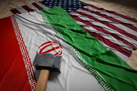 Large hammer, american and Iranian flags resting on desert sand
