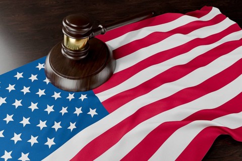 American flag and wooden gavel resting on desk