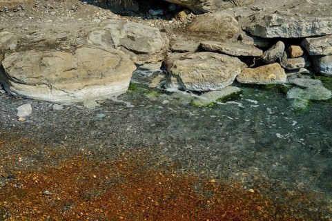 Rocky shore with clear and gently foaming waves, natural textures, Embros Thermal Baths, Kos,