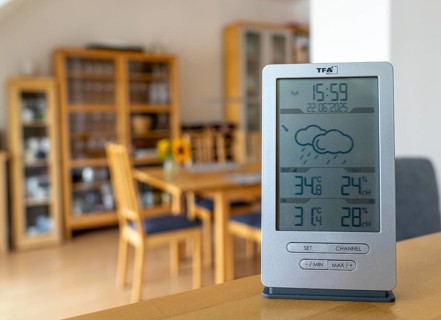 Summer heat, digital thermometer in an attic flat, city centre, outside temperature in the