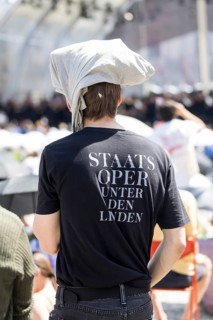 A visitor protects himself from the sun with fabric on his head at the Staatsoper fÃ¼r alle, a free