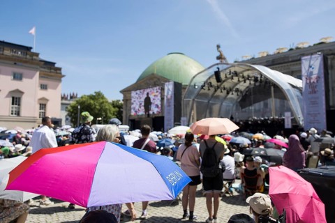 Visitors with parasols at the Staatsoper fÃ¼r alle, a free open-air concert with conductor