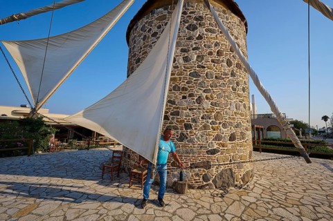 Stone windmill with a man fixing the sail, Windmill, Antimacheia, Kos, Dodecanese, Greek Islands,