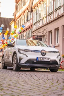 Car in a narrow alley in the old town centre, surrounded by half-timbered houses and lanterns in a
