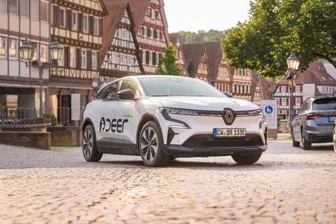 Car on a cobbled square surrounded by half-timbered buildings, summer atmosphere in the early