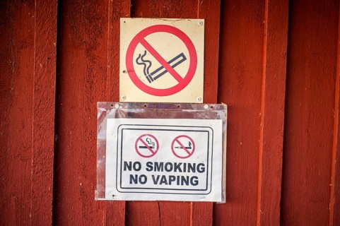 Red wall with no smoking signs prohibiting smoking and vaping, Svedjehamn, Kvarken Archipelago,