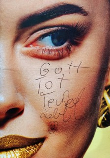 Large-scale advertising poster depicting a woman's face and the inscription Gott tot, Teufel lebt,