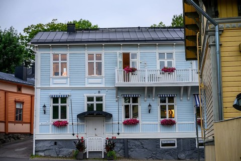 Street scene in the old town of Naantali, two-story light blue wooden house with balconies