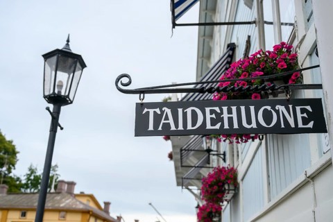 Street scene in the old town of Naantali, street view with lamp and hanging flowers in front of a