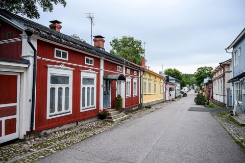 Street scene in the old town of Naantali, colorful traditional buildings on a paved, quiet street,