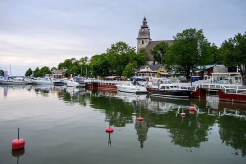 Marina Port of Naanatali with boats and a church surrounded by trees, a peaceful maritime scene,