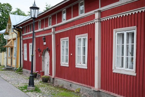 Street scene in the old town of Naantali, red historic wooden building with decorative windows on a