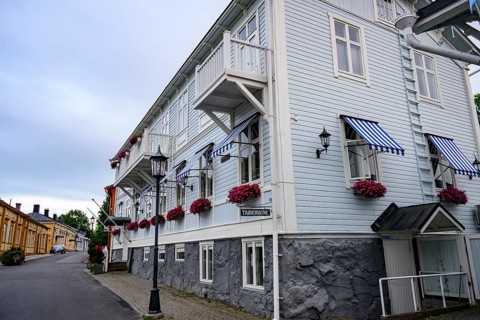 Large historic building with balconies and blooming flowers, on a quiet street in the old town,