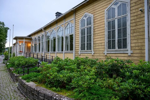 Street scene in the old town of Naantali, yellow building with tall, narrow windows and shrubs