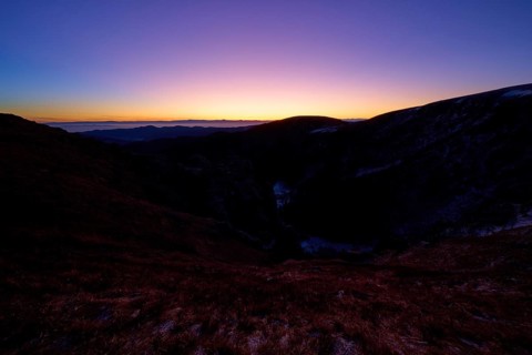 Sunrise over dark mountains with purple sky at dusk, looking towards the Rhine Valley, Martinswand,
