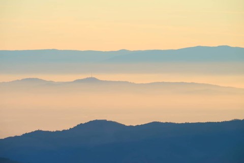 Gentle mountain silhouettes in morning haze with warm sunlight, looking towards the Rhine Valley,