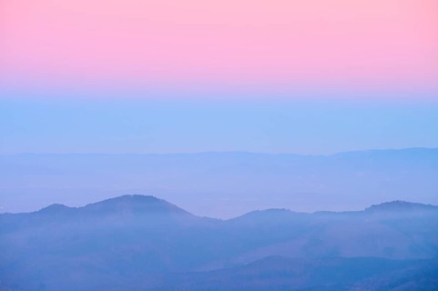 Pale hills in evening fog under a pink sky, looking towards the Rhine Valley, Hohneck, La Bresse,