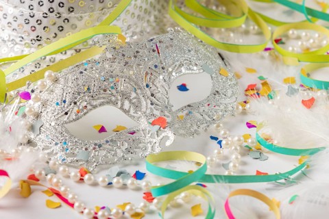 Silver carnival mask with pearls and colorful confetti on white background