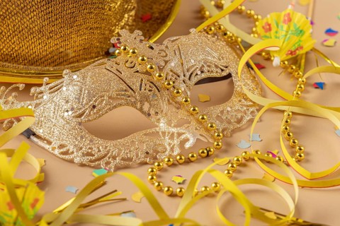 Golden mask with pearls surrounded by carnival decoration