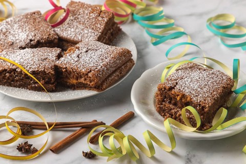 Spice cake with powdered sugar surrounded by colorful streamers