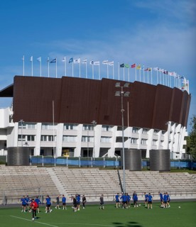 Football players train in front of Olympic Stadium or Finnish Olympic Stadium, architects Yrjö