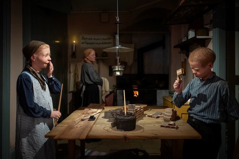 Children glue matchboxes together while working from home, child labor, historical scene recreated,