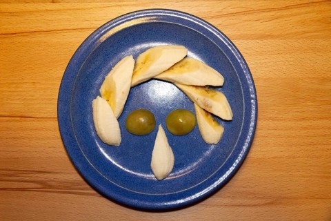 Fruit plate as a face, humor, banana, grapes