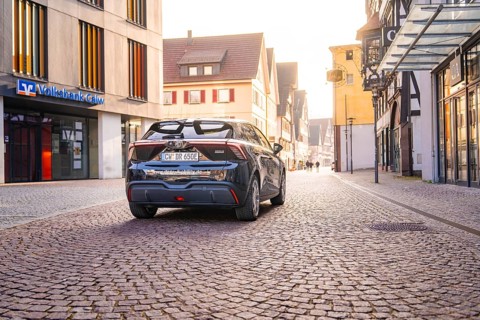 Car parked in a quiet old town with cobblestones and old buildings in diffuse light, MG4 electric