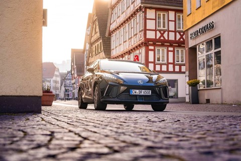 Black car in an almost empty cobblestone street in the old town, MG4 electric car, Deer