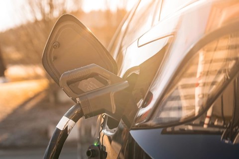 Electric car at a charging station at sunset, modern design emphasized by lighting, MG4 electric