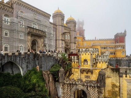 Tourists visiting the palace Palácio Nacional da Pena, foggy day, Sintra, Portugal