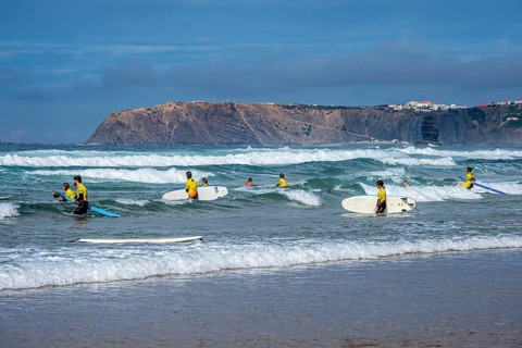 Participants in a surfing course go into the water, beach Praia de Vale Figueiras, village Arrifana