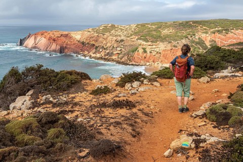 Hiking woman, view over cliff, Fishermens Trail, Rosa Vicentina, western Algarve just north of cape