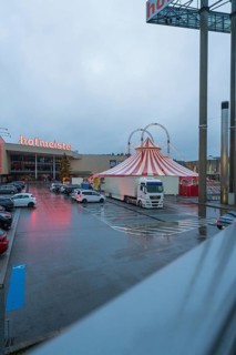 Hofmeister shopping center with circus tent and parked cars at dusk, stuffing machine used at