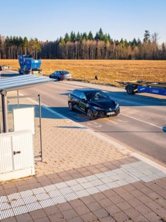 A car moves on a road flanked by other vehicles and trees, MG4 electric car, Deer e-Carsharing,
