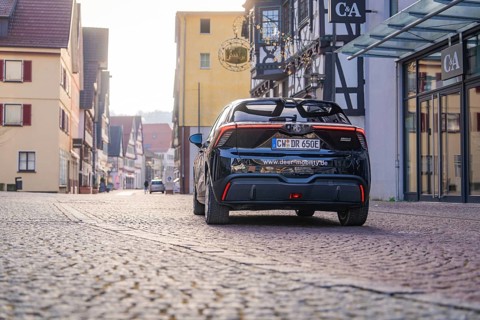 A car is parked on a cobblestone street in a picturesque town with half-timbered houses, MG4