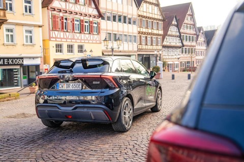 Car in an old town with half-timbered houses and cobblestone streets, MG4 electric car, Deer