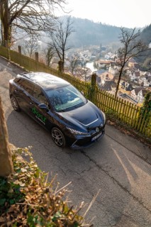 Car on a hill with a view of a village and a panoramic view of the surrounding area, MG4 electric
