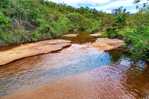 A tranquil river flowing through the forest on the outskirts of the city of Ouro Preto in Minas