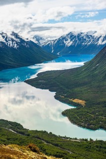 View of snowy mountains in spring and turquoise Kenai Lake with reflection, Slaughter Ridge Trail,